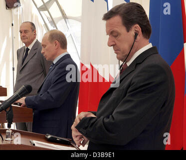 (Afp) - Le Chancelier allemand Gerhard Schroeder (R-L) regarde sa montre-bracelet lors d'une conférence de presse avec le président russe Vladimir Poutine et le président français Jacques Chirac à Minsk, en Russie, le dimanche 3 juillet 2005. Après une réunion trilatérale Schroeder, Poutine et Chirac participera à la c Banque D'Images