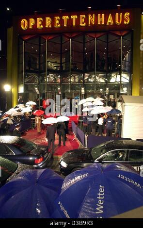 (Afp) - Des invités à pied jusqu'au tapis rouge grâce à la pluie de la première de l'l'ABBA encore de 'Mamma Mia' dans l'opéra de Hambourg, le 3 novembre 2002. La comédie musicale qui présente les résultats du groupe pop ABBA a ouvert ses portes à Hambourg après éclatement records à Londres, New York, Toronto, Lo Banque D'Images