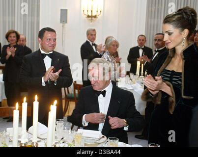 (Afp) - Le Roi Abdallah II de Jordanie (L) et de la Reine Rania applaudir lors d'une réception du Président allemand Johannes Rau (C) au château de Bellevue à Berlin, le 22 octobre 2002. Le couple royal jordanien est sur trois jours de visite d'État en Allemagne. Banque D'Images