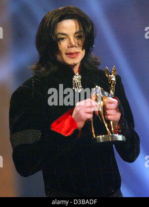 (Afp) - La pop star Michael Jackson tient dans ses mains son 'Millenium Bambi' qu'il a reçu de 'Popstar du siècle' à la Bambi award show dans l'Estrel Convention Center à Berlin, le 21 novembre 2002. Dans son discours d'acceptation, le 44-year-old King of Pop a dit en allemand "Berlin, ich liebe dich Banque D'Images