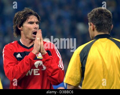 (Afp) - L'attaquant Thomas Brdaric de Leverkusen (L) nous amène à l'assistant arbitre Guenter Perl pas de punir son coup avec une carte jaune lors de la match de football Bundesliga Bayer 04 Leverkusen contre le FC Schalke 04 à Gelsenkirchen, Allemagne, 9 novembre 2002. Le match s'est terminé 1:0 pour Leverkusen. Banque D'Images