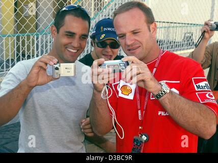 (Afp) - pilote de Formule 1 brésilien Rubens Barrichello (R) et pilote de Formule 1 colombien Juan Pablo Montoya s'amuser avec les appareils photo numériques avant le Grand Prix du Japon à Suzuka, Japon, 10 octobre 2002. Banque D'Images