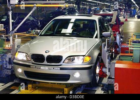 (Afp) - Un employé met la touche finale à une BMW de la série 3 dans l'usine Usine à Munich, 6 décembre 2002. Battant un marché automobile mondial mou, allemand de voiture BMW Groupe de vente levée passé 1 millions d'unités pour la première fois en 2002, grâce à sa re-création de l'icône des années 1960, British Banque D'Images