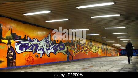 (Afp) - Une femme déambule passé orné de murs graffiti art dans le passage inférieur pour piétons près de la gare principale à Magdebourg, en Allemagne de l'Est, 29 janvier 2003. La première loi anti-graffiti sera lu au Bundestag par l'Union chrétienne-démocrate (CDU) le 30 janvier 2003. Des frais de nettoyage, Banque D'Images