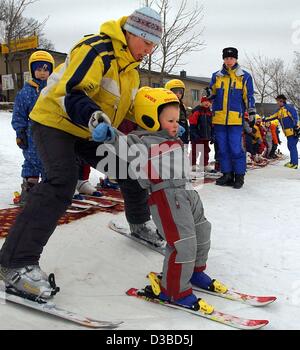 (Dpa) moniteur de ski - Melanie Ellinger enseigne les bases du ski alpin à l'une de ses plus jeunes apprenants à un jardin d'enfants à Oberwiesenthal, Allemagne de l'Est, 22 janvier 2003. Banque D'Images