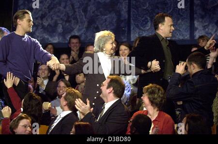 (Dpa) - US acteurs Leonardo DiCaprio (L) et Tom Hanks (R) de marche Erika, une dame de l'auditoire, de retour à son siège après avoir posé avec elle pour une photo de famille au cours de l'émission de télévision allemande "Wetten Dass... ?' (pari que... ?), dans Offenbach, Allemagne, 25 janvier 2003. Le Hollywood stars promu leur sw Banque D'Images