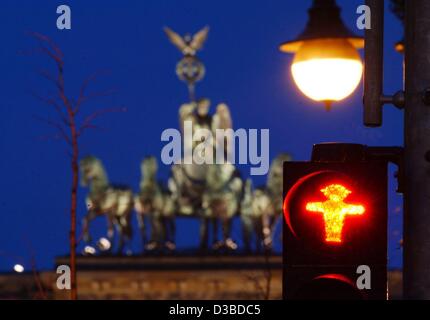 (Afp) - une scène de nuit présente le quadrige sur le dessus de la porte de Brandebourg et un piéton rouge lumière à la place de Paris en Berin, 27 janvier 2003. À la recherche de moyens d'économiser de l'argent, le sénat de Berlin prévoit de privatiser le capital a des feux de circulation. "Nous voulons un investisseur privé pour l'exploitation, le contrôle d'un Banque D'Images