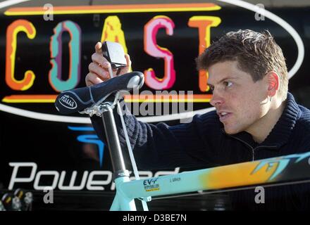 (Afp) - le cycliste allemand Jan Ullrich mesure la hauteur de sa selle de vélo de course après son arrivée dans le camp d'entraînement de sa nouvelle équipe professionnelle côte à Gandia, Espagne, 17 janvier 2003. Champion du monde de cyclisme Jan Ullrich a signé un contrat de trois ans avec l'équipe allemande l'autre. Il a annoncé 25 Banque D'Images