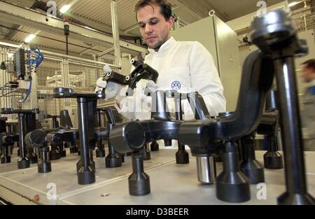 (Afp) - Un employé de Volkswagen est contrôle des faisceaux pour le nouveau modèle VW Touran dans le nouvel établissement à Braunschweig, Allemagne, 13 janvier 2003. L'immeuble est de 30 000 mètres carrés grand et coûtent 50 millions d'euros. Il a été officiellement mis en service le 14 janvier 2003. Le Touran est un compact van b Banque D'Images