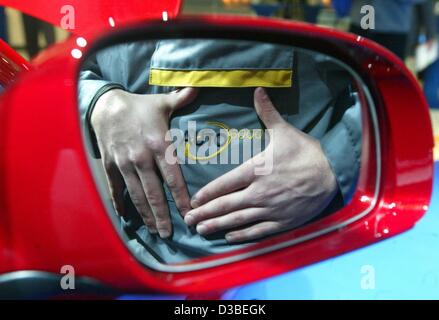 (Afp) - Le logo 'Auto 5000' se reflète dans un miroir de la nouvelle VW Touran au cours de la présentation officielle du nouveau modèle de Wolfsburg, Allemagne, 13 janvier 2003. Le Touran est un van, selon le modèle de la VW Golf. Les travailleurs étaient employés dans le cadre du projet '5000' (5 000 mal 5000 tim Banque D'Images