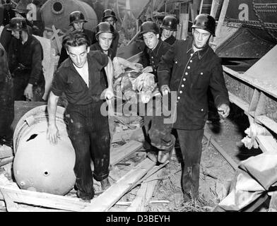 (Afp) - Les secouristes porter loin l'une des victimes de l'explosion chimique à l'usine chimique de BASF à Ludwigshafen, Allemagne de l'après-guerre, le 28 juillet 1948. 207 personnes ont été tuées, environ 3 800 blessés et des dommages ont été causés par l'explosion d'une citerne à bogies, chargé avec l'éther, sur le fa Banque D'Images