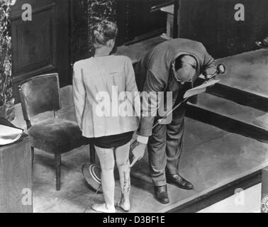 (Afp) - les fichiers témoin J. Bzize de Pologne montre les cicatrices sur sa jambe droite, qui étaient le résultat des expériences médicales lorsqu'elle est emprisonnée à la camp de concentration de Ravensbrueck, photographié lors de la 'Doctors Procès" du procès de Nuremberg à la cour à Nuremberg, Allemagne, 22 décembre 1946. Banque D'Images