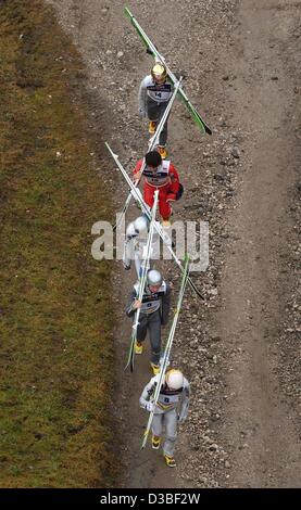 (Afp) - Les cavaliers portent leurs skis Ski montée le long d'un champ vert jusqu'à l'Olympia Schanze lors d'une formation pour les quatre tournois Hill à Garmisch-Partenkirchen, Allemagne, 31 décembre 2002. Banque D'Images