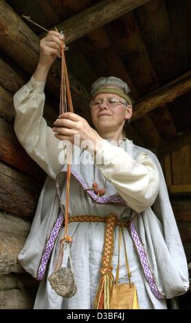 (Afp) - Erna Kuhfal, un employé du musée, est vêtu d'un costume tradition et démontre une ancienne technique de tissage de la façon dont sa a été appliquée par l'ancien Langobards à l'atelier en Zehtlingen Langobard, Allemagne, 18 juin 2003. La tribu germanique des Langobards vivaient dans la région pari Banque D'Images