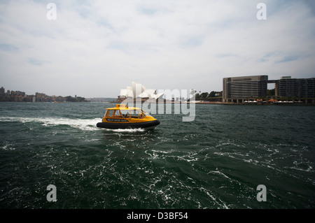 Les taxis jaune circulaire approche clé avec l'Opéra de Sydney dans l'arrière-plan, Sydney, Australie Banque D'Images