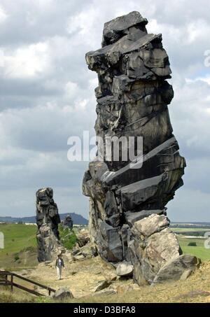 (Afp) - une jeune femme regarde le rocher appelé 'Teufelsmauer' (Mur du diable) dans les montagnes du Harz près de Weddersleben, près de Quedlinburg, Germnany, 24 juin 2003. Les formations rocheuses sont apparus environ 70 millions d'années, et depuis 1852 ont été sous la protection de l'environnement. Banque D'Images