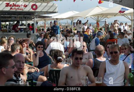 (Afp) - une foule de touristes allemands profiter du soleil sous les parasols ombragés pendant qu'ils s'asseoir à l'extérieur et de prendre un verre au bar de plage Ballermann le long de la promenade à El Arenal près de Palma sur l'île de Majorque, Espagne, le 5 juin 2003. Majorque est la plus grande des îles Baléares avec un Banque D'Images