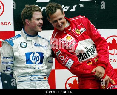 (Afp) - L'allemand champion du monde de Formule 1 Michael Schumacher (Ferrari) (R) se distingue avec son frère pilote de Formule 1 allemand Ralf Schumacher pendant la cérémonie de remise des prix sur le circuit Gilles Villeneuve de la formule 1 après le Grand Prix du Canada à Montréal, Canada, 15 juin 2003. Michael Sc Banque D'Images