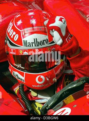 (Afp) - L'allemand champion du monde de Formule 1 Michael Schumacher (Ferrari) frappe sa main à son casque comme un geste indiquant qu'il a bientôt après avoir remporté le Grand Prix du Canada sur le circuit Gilles Villeneuve circuit de Formule 1 à Montréal, Canada, 15 juin 2003. Michael Schumacher remporte le r Banque D'Images