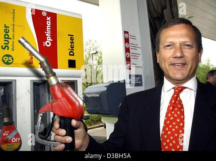 (Afp) - Adrian Loader, président de Shell l'Europe, pose avec un bouchon de remplissage à la main à une station service Shell à Berlin, 6 mai 2003. Il a présenté un tout nouveau carburant synthétique produit à partir du gaz naturel, qui est actuellement testée par le constructeur automobile Volkswagen. Le nouveau carburant est appelé Banque D'Images