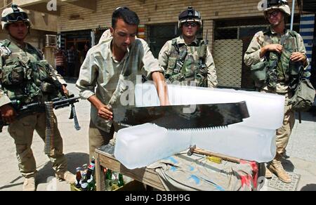 (Afp) - Des soldats américains de la 101e Division aéroportée stand by comme une coupe de glace iceman iraquien un bloc de glace à Bagdad, Iraq, 14 mai 2003. La glace est conçu pour le refroidissement des boissons sans alcool à un moment où les températures dans Bagdad atteindre jusqu'à 40 degrés Celsius. Banque D'Images