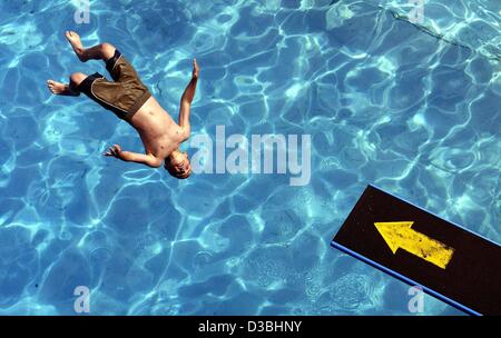 (Afp) - Un garçon saute d'un plongeoir dans l' eau à un lido, à Kaiserslautern, Allemagne, 2 juin 2003. Accueil chaleureux, lumineux et ensoleillé wheater est la prévision pour l'Allemagne. Banque D'Images