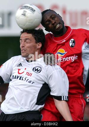 (Afp) - Le milieu de terrain de Fribourg Rolf-Christel Guie-Mien de Congo (R) dans une position en duel avec le milieu de terrain du Burghausen Bjoern Hertl durant la seconde partie de football Bundesliga SC Freiburg contre Wacker Burghausen de Burghausen, Allemagne, 11 mai 2003. Fribourg gagne 2-1 et se classe en deuxième place du Zwei Banque D'Images