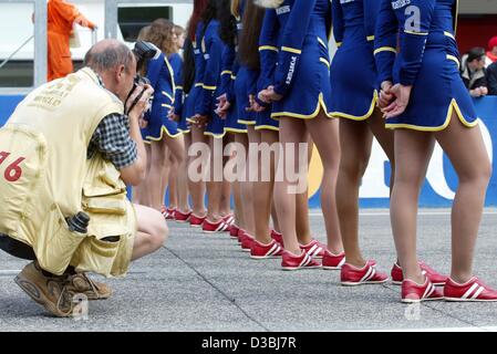 (Afp) - Un photographe prend une photo d'une ligne de Grid Girls à la piste de course de Formule 1 à Imola, Italie, le 20 avril 2003. Banque D'Images