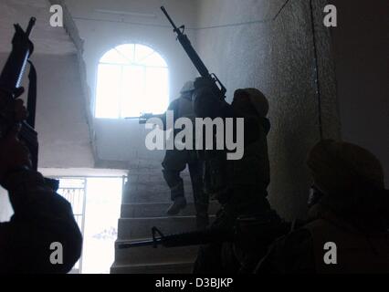 (Afp) - Des US Marines de la 3e (3e Bataillon de Reconnaissance Amoured LAR) qui sont sur une mission de reconnaissance conduite une maison de recherche le siège régional du parti Baas autour de 90 kilomètres au sud de Bagdad près d'un Nu Maniyah, Iraq, 2 avril 2003. Les Marines américains à se préparer à la decis Banque D'Images