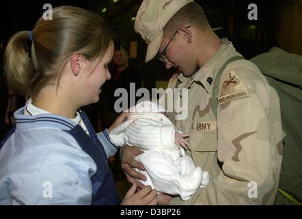 (Afp) - un soldat américain Mark Setser (R) d'Ottawa, Il., regarde affectueusement sa fille de sept semaines, tandis que sa femme Reni (L) de l'Allemagne ressemble sur, à son arrivée à l'US Air Force Base à Francfort, Allemagne, 25 septembre 2003. Le bébé est né alors qu'il était en poste en Iraq. Les subventions de l'armée américaine Banque D'Images