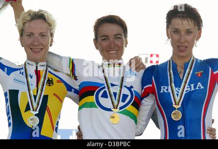 (Afp) - Les trois lauréats de la course contre la montre des femmes au Championnat du monde de cyclisme, l'Espagne Joana Somarriba Arrola (C, or), l'Allemagne, Judith Arndt (L, argent), et le russe Zoulfia Zabirova, posent avec leurs médailles sur le podium à Hamilton, Canada, 8 octobre 2003. Ils ont gagné l'individu Banque D'Images