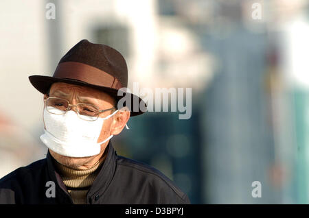 (Afp) - Un homme âgé qui porte un masque de visage pour empêcher la propagation des germes à Busan, Corée du Sud, le 19 décembre 2004. Banque D'Images