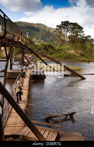 Madagascar, Ranomafana, touristiques et guides crossing pont temporaire au-dessus de la rivière Namorona cyclone vieux pont endommagé ci-dessous Banque D'Images
