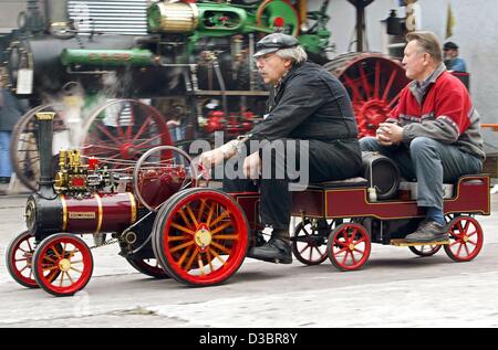 (Afp) - Deux hommes faire un tour sur un modèle de la machine à vapeur 'Chester' au cours d'une réunion d'amateurs de moteur à vapeur à Paderborn, Allemagne, 28 septembre 2003. Environ 100 locomotives à vapeur ont été présentés au cours de la réunion. Banque D'Images