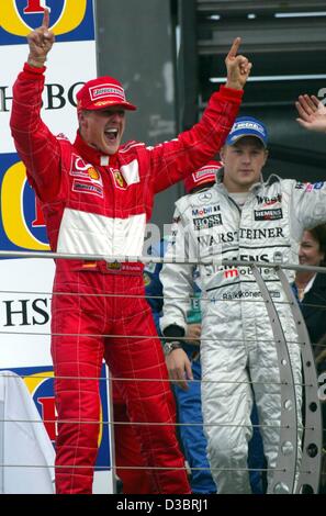 (Afp) - L'allemand champion du monde de Formule 1 Michael Schumacher célèbre sur le podium après avoir conduit sa Ferrari à la victoire dans le Grand Prix des États-Unis à Indianapolis, 28 septembre 2003. Schumacher a remporté l'avant de la Finlande a Kimi Raikkonen (R) de McLaren-Mercedes et collègues allemands Heinz-Harald Frentzen de Saub Banque D'Images