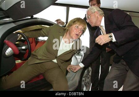 (Afp) - Jürgen Hubbert, PDG de DaimlerChrysler, contribue à Angela Merkel, présidente de la CDU, parti de l'opposition allemande de sortir d'une voiture de sport Mercedes SLR lors du salon international de l'auto de l'IAA de Francfort, Allemagne, 15 septembre 2003. Merkel a exigé que la décision de la coalition rouge-vert enfin st Banque D'Images