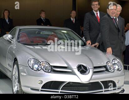 (Afp) - Le Chancelier allemand Gerhard Schroeder (R) se tient à côté d'une Mercedes SLR McLaren lors de l'ouverture officielle de l'International Auto Show (IAA) à Francfort, 11 septembre 2003. Dans l'arrière-plan droit Juergen Hubbert, PDG de Mercedes, et dans l'arrière-plan à gauche de Schroeder Bernd Gottschalk ( Banque D'Images