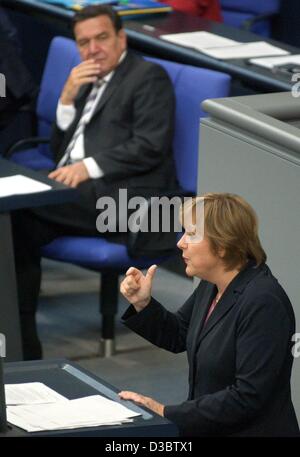 (Afp) - Le Chancelier allemand Gerhard Schroeder l'écoute d'un discours d'Angela Merkel, présidente de la CDU, parti de l'opposition allemande au cours du débat sur le budget au Bundestag à Berlin, 10 septembre 2003. L'Allemagne a dépassé la limite de la zone euro avec un embarrassant 3,6  % l'an dernier et le gouvernement Banque D'Images