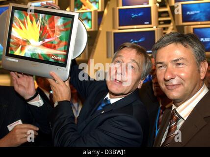 (Afp) - Le ministre allemand de l'économie, Wolfgang Clement (L) et le maire de Berlin Klaus Wowereit regarder ecrans plats pendant leur ouverture à pied autour de la 44e Internationale Funkausstellung IFA (International radio exposition) à Berlin, le 29 août 2003. La 44e CDI aura lieu du 29 août au 3 sept. Banque D'Images