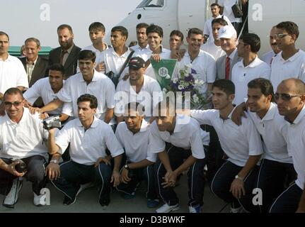 (Afp) - L'entraîneur allemand de l'équipe nationale de soccer, Bernd Stange (top R, avec capuchon), pose avec ses joueurs à leur arrivée à l'aéroport de Munich, 27 août 2003. L'équipe irakienne pour les championnats du monde en 2006 jusqu'au 13 septembre 2003 à Bad Woerishofen, Bavière. Banque D'Images