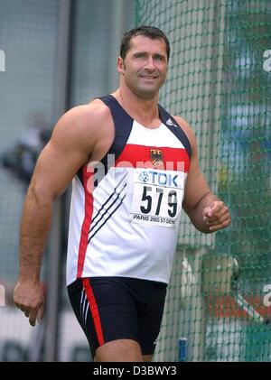 (Afp) - L'athlète allemand Lars Riedel sourire alors qu'il quitte le ring après sa tentative durant le lancer à l'événement 9es Championnats du monde d'athlétisme au Stade de France à Paris, le 24 août 2003. Le quintuple champion du monde s'est qualifié pour la finale avec 64,52 mètres. Banque D'Images