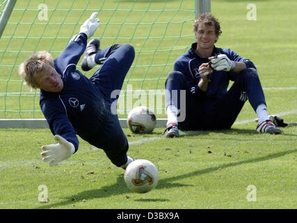 (Afp) - le gardien de but Allemand Jens Lehmann (R) regarde son collègue Oliver Vasiliu sautant pour faire une sauvegarde au cours d'une formation de l'équipe de football allemande dans Ostfildern-Ruit, près de Stuttgart, Allemagne, 18 août 2003. L'Allemagne fait face à l'Italie dans un match amical le mercredi 20 août. Banque D'Images