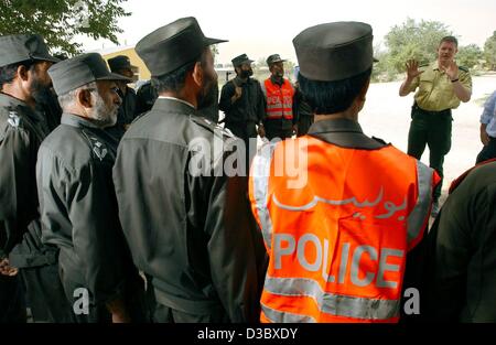 (Afp) - Un officier (dos, R) de la police fédérale des frontières allemande explique à un groupe de recrues de la police afghane, l'un d'eux porte un gilet de couleur orange qui se lit "Police", comment se comporter lors d'une inspection de véhicules de police et des voitures dans les locaux de l'académie de police de Kaboul, l'Afghanist Banque D'Images