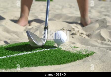 (Afp) - un golfeur joue un départ sur la plage de Nice sur l'île Usedom, Allemagne, 4 août 2003. Derrière les golfeurs sont volleyballers découvrir la plage comme un lieu idéal pour leur sport. Cependant, beach golf n'est pas joué dans le sable, mais sur une surface synthétique. Les 120 m² grand artifi Banque D'Images