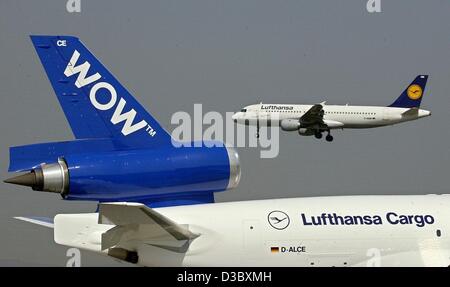 (Afp) - Un avion de Lufthansa Cargo stationné survole une MD-11 de l'airfright WOW alliance à l'aéroport de Francfort, 8 août 2003. WOW a été fondée il y a trois ans en tant qu'alliance des compagnies aériennes Japan Airlines, Lufthansa (Allemagne), SAS (Scandinavie) et Singapore Airlines. Au cours des derniers mois spéculum Banque D'Images