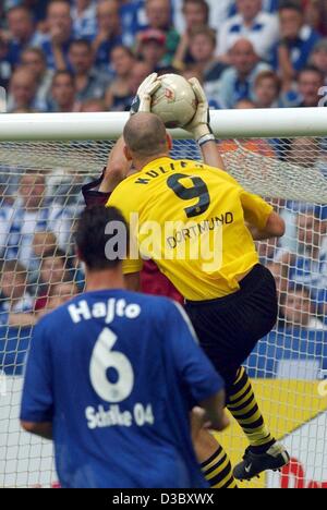 (Afp) - le gardien de Schalke Frank Rost (couverte) sauve le ballon de Dortmund est l'avant tchèque Jan Koller (no. 9) tandis que le défenseur de Schalke Polonais Tomasz Hajto (no. 6) lors du premier tour de jeu en Bundesliga contre le FC Schalke 04 et le Borussia Dortmund à Gelsenkirchen, Allemagne, 2 août 2003 Banque D'Images