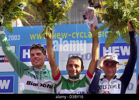 (Afp) - le cycliste italien Paolo Bettini (C) de l'équipe Quickstep-Davidamon cheers après avoir remporté la HEW Cyclassics-Coupe du Monde de Hambourg, le 3 août 2003. Sur la droite est l'Italien Davide Rebellin de l'équipe Gerolsteiner et troisième l'Allemand Jan Ullrich de team Bianchi. Bettini est maintenant Banque D'Images