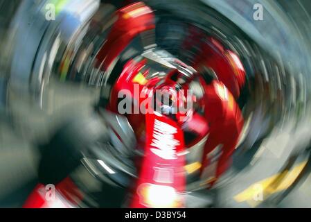 (Afp) - L'effet de spin photo montre Champion du Monde et actuel leader au classement général, l'Allemand Michael Schumacher, pilote de Formule 1 dans sa voiture de course Ferrari étant repoussé dans la fosse après la formation gratuite à l'hippodrome d'Hockenheim, Allemagne, 1 août 2003. Schumacher a terminé avec la onzième meilleure ti Banque D'Images