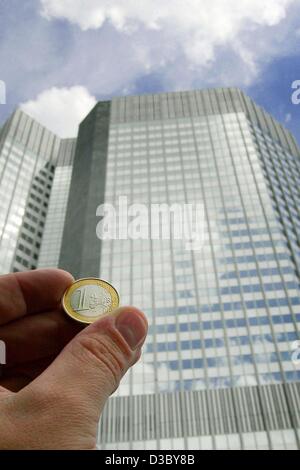 (Afp) - Une pièce en euros est maintenu jusqu'en face de la tour de la Banque centrale européenne (BCE) dans Frannkfurt, 25 juillet 2003. Au cours des deux dernières années, la BCE a abaissé les taux d'intérêt de 2,5  %, qui presque ne montrent aucun effet sur les emprunts privés. Les avantages accordés par la BCE n'atteignent pas t Banque D'Images