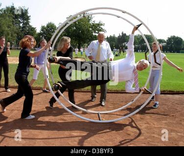 (Afp) - Edmund Stoiber, le ministre et l'ancien chancelier chandidate, rouleaux autour d'une arène de sports dans un gymwheel durant un événement promotionnel pour le sport, à Nuremberg, Allemagne, le 23 juillet 2003. Dans l'arrière-plan Le ministre de l'Intérieur bavarois Guenther Beckstein (C) regarde avec scepticisme, avant qu'il Banque D'Images